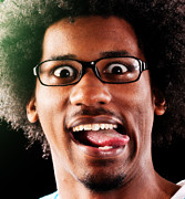 Happy young wide-eyed geek plays the fool, sticking tongue out Photograph by RapidEye