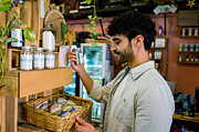 Man shopping at an organic market and looking at supplements Photograph by Hispanolistic