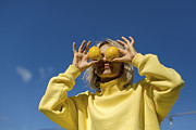 Mid adult woman covering eyes with lemon during sunny day Photograph by Westend61