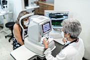 Optometrist examing patient's eyes Photograph by FG Trade