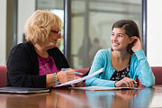 Preteen girl meeting with school counselor or therapist Photograph by SDI Productions