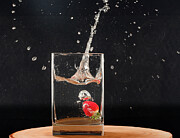 Strawberry dropped into water vase on wooden slab and resulting splash Photograph by Mike Worley