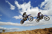 Two female motocross riders in midair, side view Photograph by Joe McBride