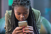 Young woman intently reading cell phone Photograph by Hello World