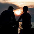 Father And Son Talking While Sitting On Stones At The Coast During Sunset Photograph by Andreas Berthold Father And Son Talking While Sitting On Stones At The Coast During Sunset Photograph by Andreas Berthold