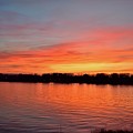 Sunset draped in vermilion over the river Photograph by Leonida Arte Sunset draped in vermilion over the river Photograph by Leonida Arte